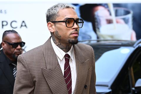 Chris Brown in a tailored suit and glasses