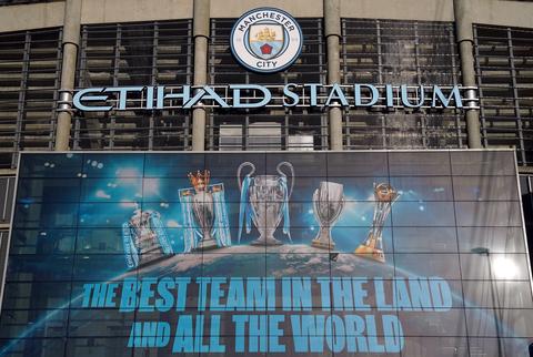 Etihad Stadium facade displaying club trophies