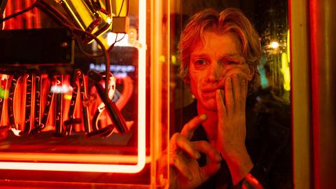 still of character melting face in red neon light