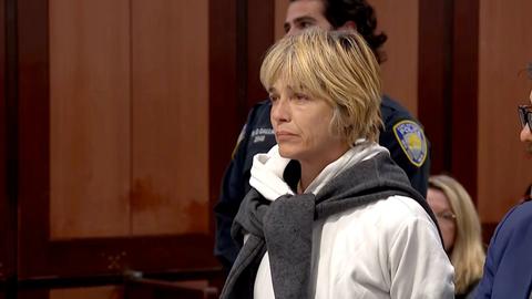 woman in white hoodie and grey sweater in court