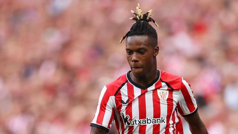 player in red and white striped kit