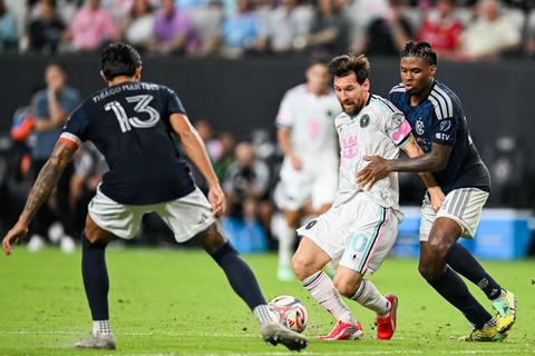 Inter Miami player in white kit with ball, pressured by two Atlanta United players