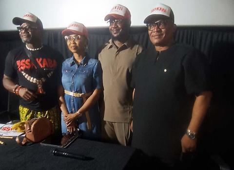 Four people wearing hats and shirts related to the film