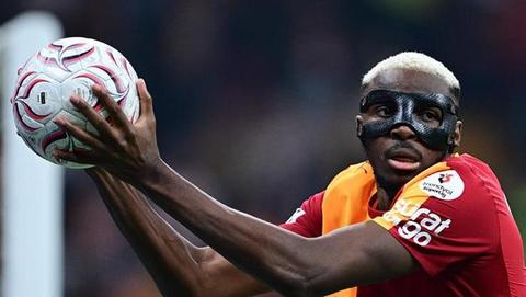 striker in Galatasaray kit holding a ball