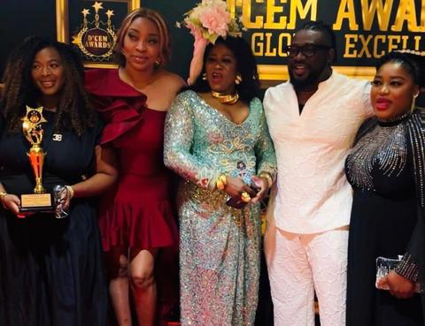 Group of people posing in front of D'CEM Awards backdrop
