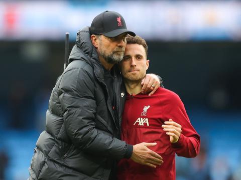 manager embracing a player in red training gear
