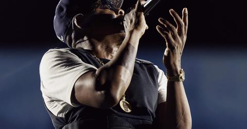 performer singing into microphone, hand raised