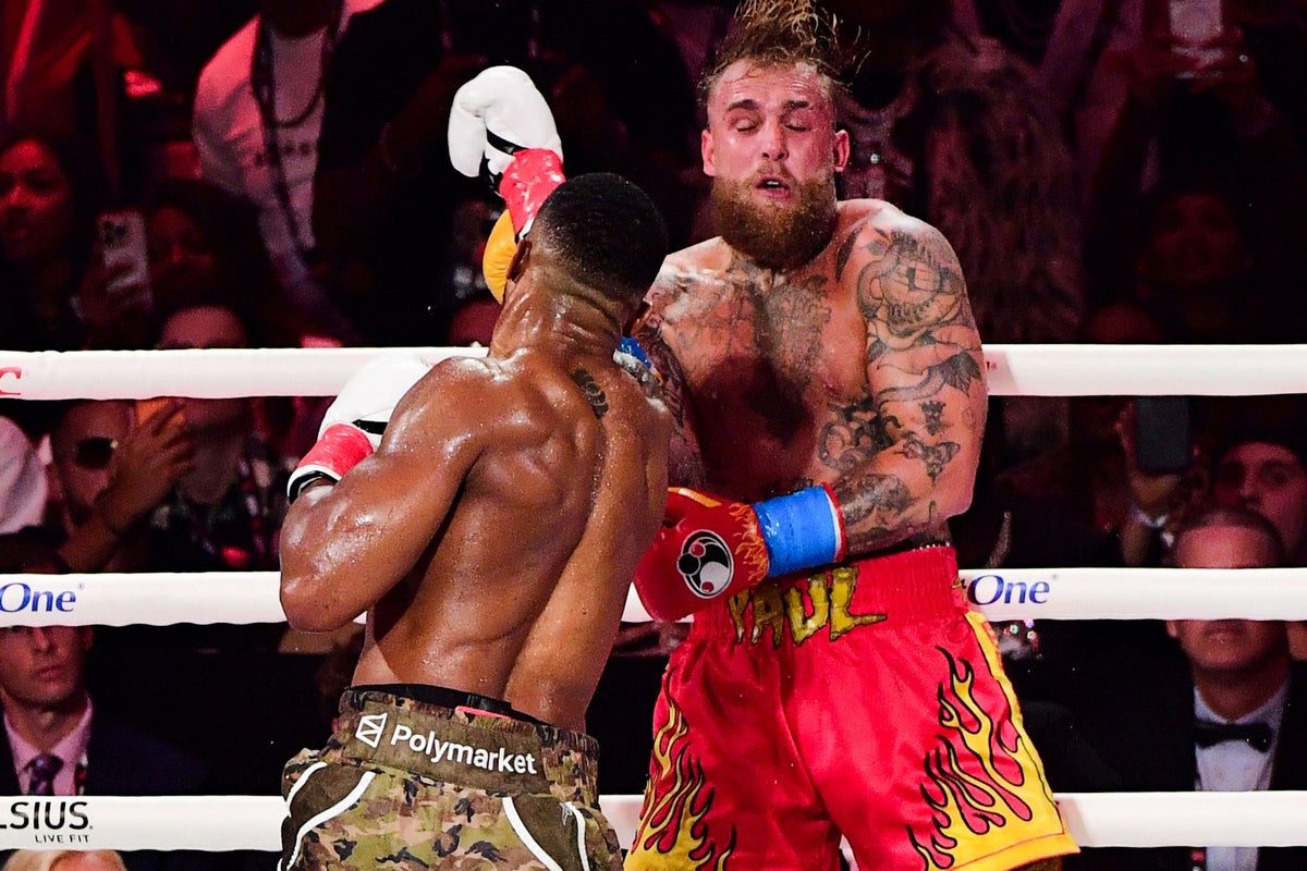 Jake Paul and Anthony Joshua in a clinch during their fight; sponsor text on shorts and ring ropes only