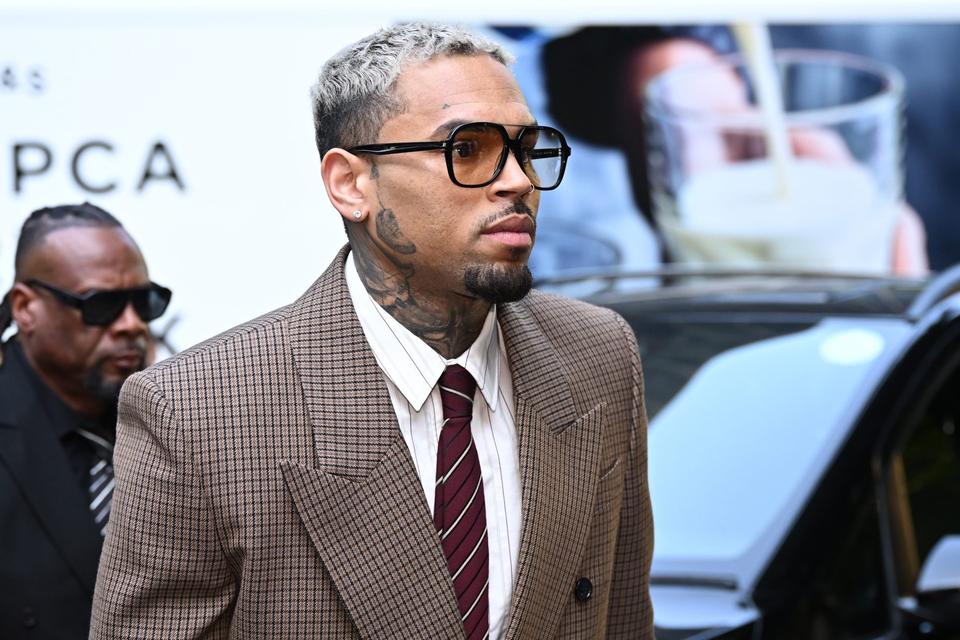 Chris Brown in a tailored suit and glasses