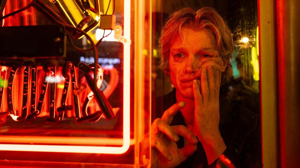 still of character melting face in red neon light