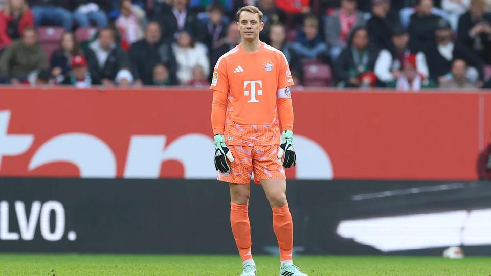 goalkeeper in orange kit standing on pitch