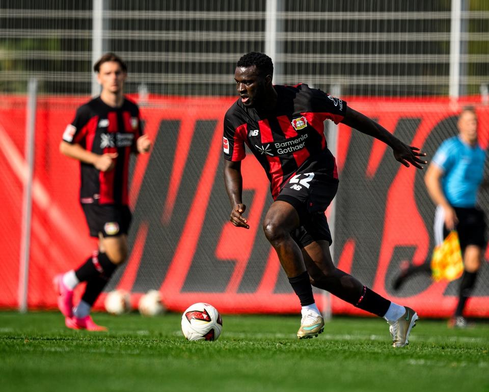 player in black and red kit with ball