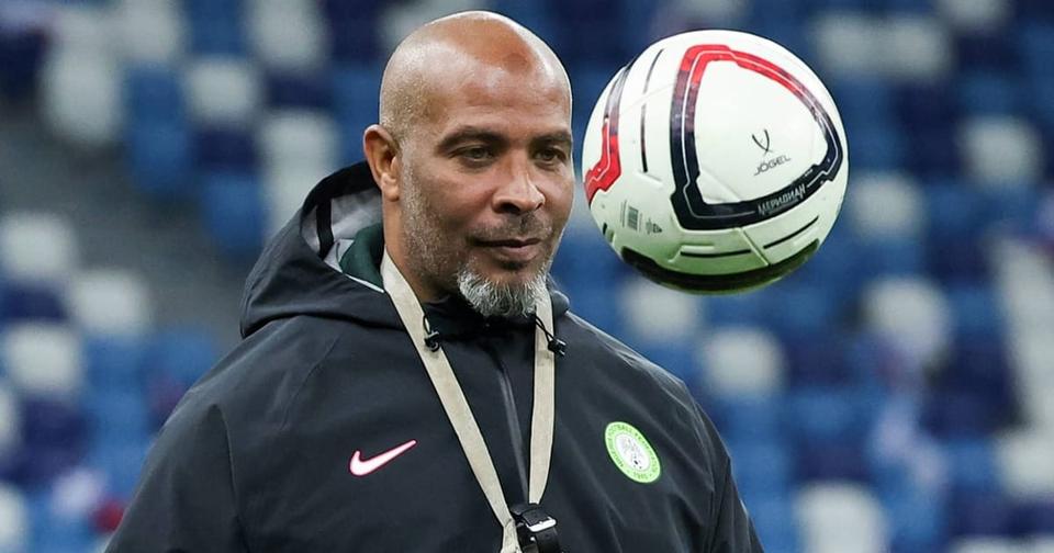 The coach watching a ball in the air at an empty stadium, training-ground scene