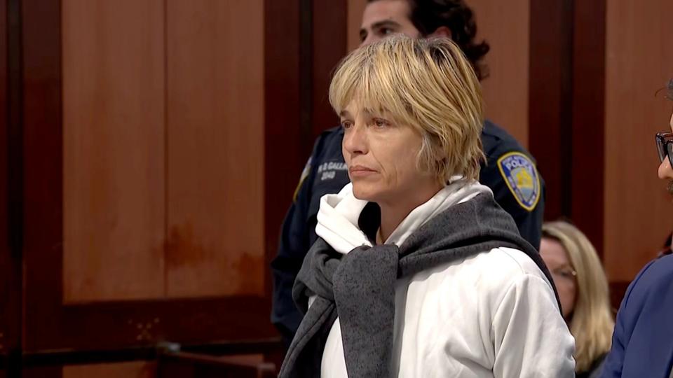 woman in white hoodie and grey sweater in court