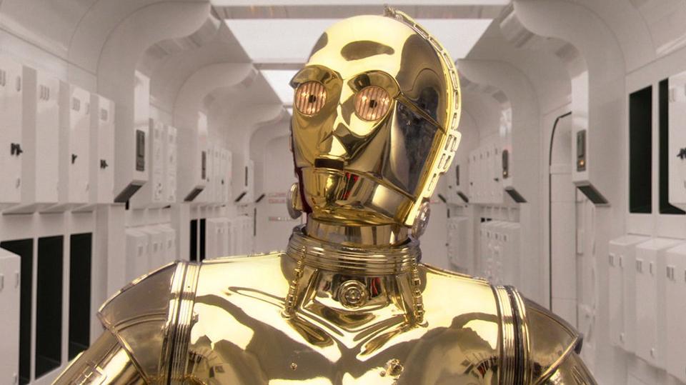 Close-up of the golden protocol droid C-3PO in a white corridor; character art only, no broadcast or event imagery