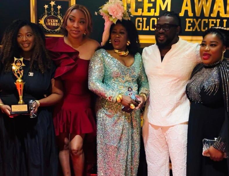 Group of people posing in front of D'CEM Awards backdrop