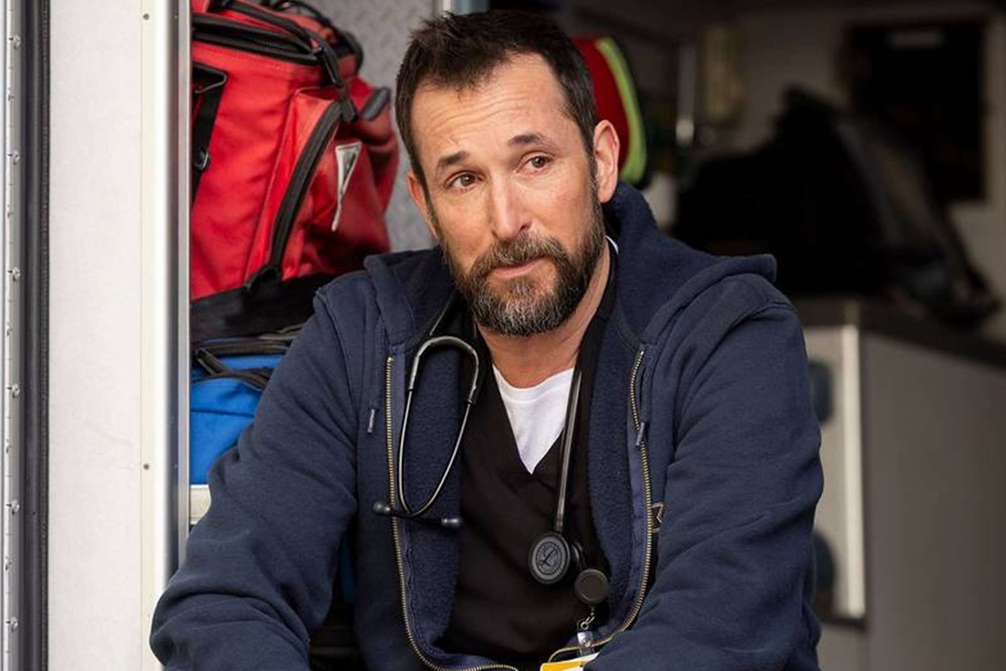 Noah Wyle as a doctor in scrubs and stethoscope on the set of The Pitt