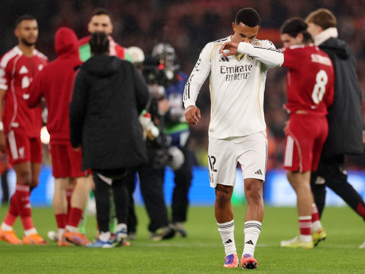 Alexander-Arnold walking off with head bowed in the white Real Madrid shirt, Liverpool players in red around him